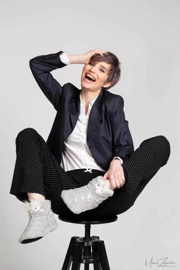 a woman sitting on a stool with her legs crossed, funny