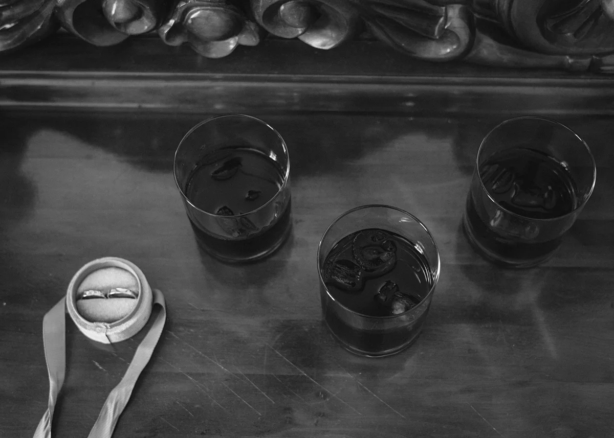 a group of glasses with liquid and a ring on a table